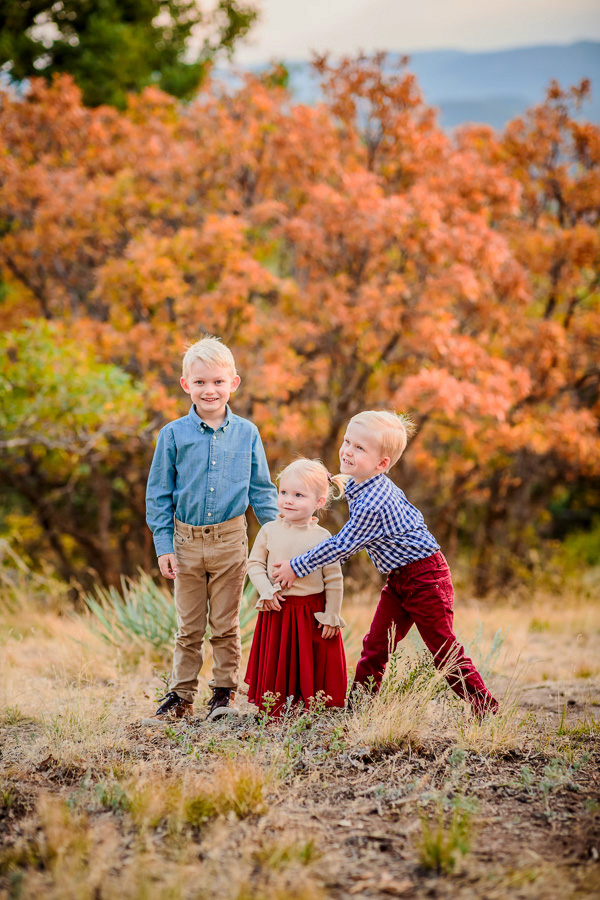 3 small children hugging each other in the mountains